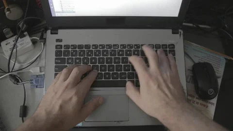 Overview shot of a man typing on a old notebook in a messed table  Stock-Footage 160359276