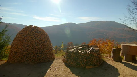 Overview of stack of firewood with mountains and sun on the background. Autumn Stock Footage 166159543