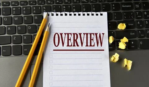 OVERVIEW - word in a white notepad on the background of a laptop with pencils Stock Photos