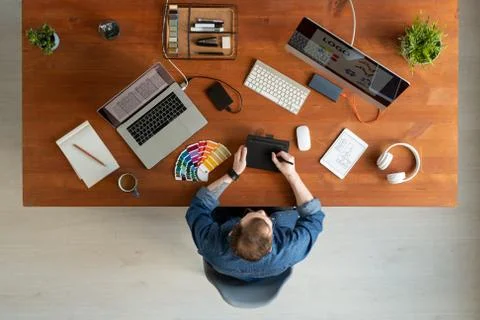 Overview of young creative software developer drawing on tablet display by table 写真素材