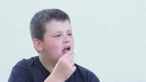 Overweight boy eats potato chips, close-up on the street. Unhealthy food Stock Footage 197431386