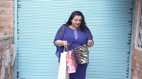 Overweight indian woman checking shopping bags and get surprised. Stock Footage 256580098