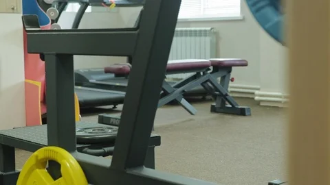 The overweight man does squats with squats with a weight disc for a barbell Video stock 108135920
