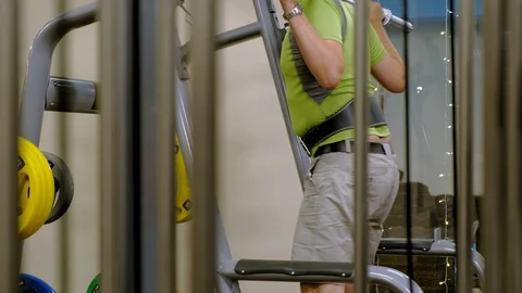 The overweight man does squats with squats with a weight disc for a barbell Video stock 111888107