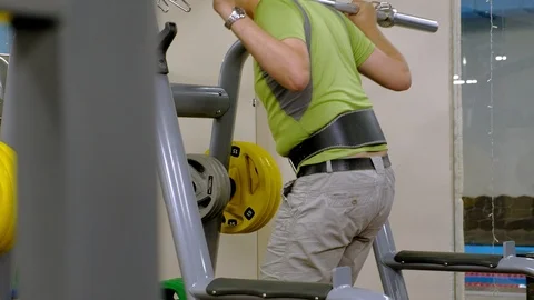 The overweight man does squats with squats with a weight disc for a barbell Video stock 111888510