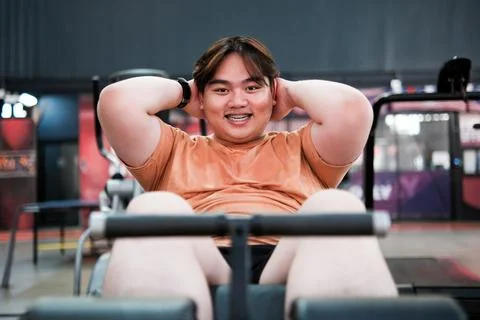 Overweight Man Doing Sit Ups at Gym. Fitness, Weight Loss, and Core Strength Stock Photos