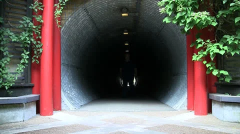 OVERWEIGHT MAN FRONT VIEW WALKING OUT OF CORRUGATED TUNNEL Stock Footage 25101587