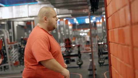 Overweight man looking at himself in the mirror Stock Footage 108786636