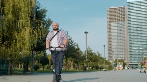 Overweight man riding e-scooter in the city. Male driving electric scooter Stock Footage 255052094