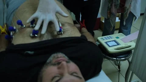 Overweight man undergoing ECG test for heart health check Stock Footage 325374811