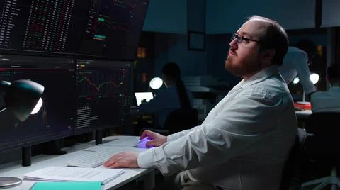 Overweight trader using computer for analyzing data with multi-screens showing Stockfoto's
