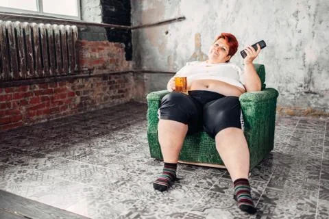 Overweight woman drinks beer, high calorie food Stock Photos