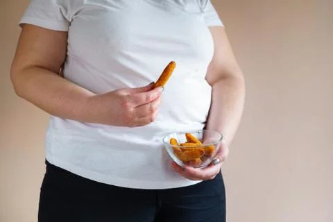 Overweight woman eating fattening chicken nuggets Stock Photos