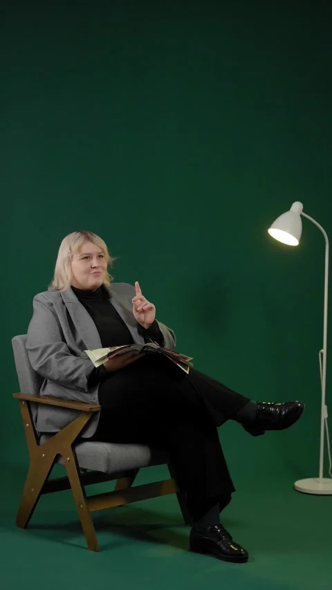 An overweight woman getting an insight while reading a magazine in a studio. Stock Footage 294711047
