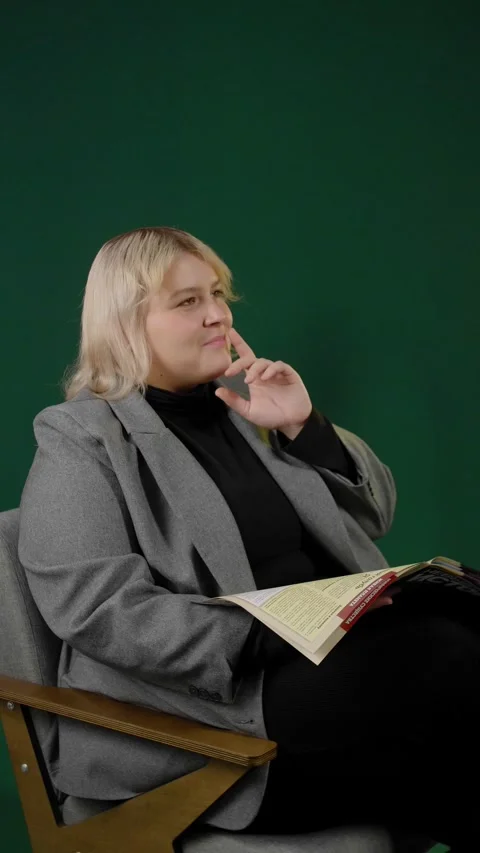 An overweight woman getting an insight while reading a magazine in a studio. Stock Footage 294711208