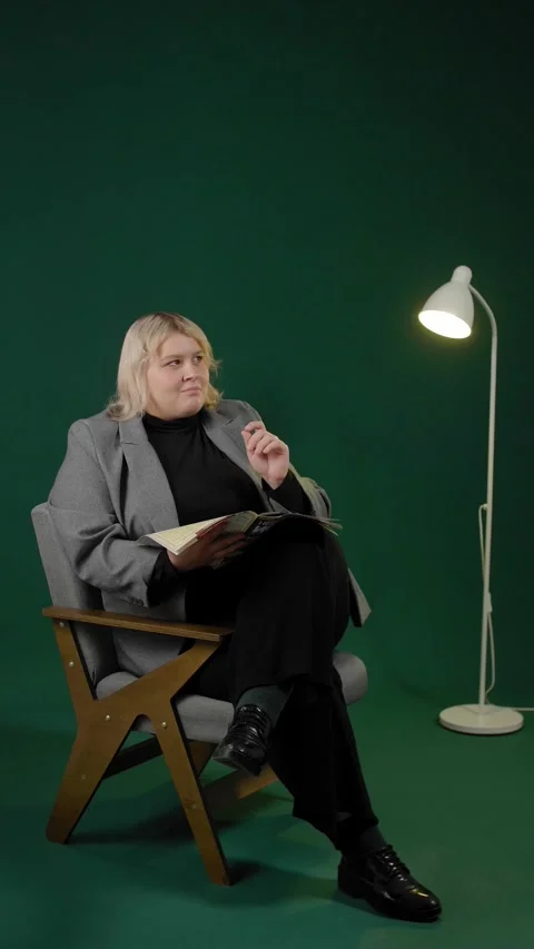 An overweight woman getting an insight while reading a magazine in a studio. Stock Footage 294711239