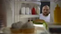 Overweight young man opening fridge at night and taking big burger, calories 4k or 4k+ Resolution