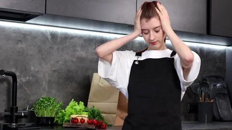 Overwhelmed chef in a modern kitchen struggles with dinner prep Vídeo Stock 296317519