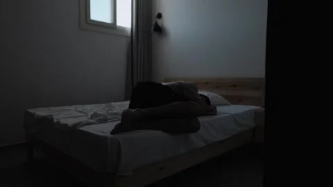 Overwhelmed man lying face down on bed in emotional despair Vídeos de archivo 346243490