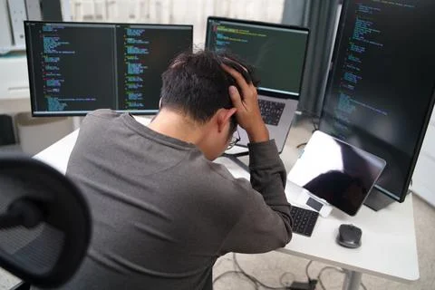 Overwhelmed Programmer Struggling with Code Debugging at a Multiscreen Setu.. 스톡 사진