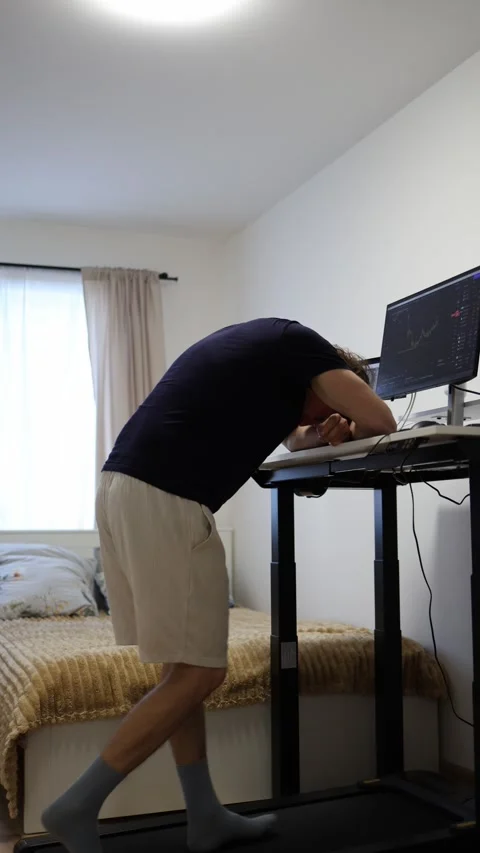 Overwhelmed remote worker rests on desk struggling through a difficult workday Stock Footage 346881189
