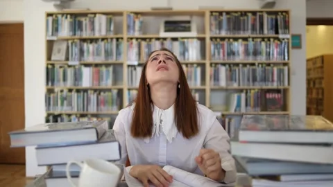 Overwhelmed student struggles with endless studying and piles of books Stock Footage 341655984