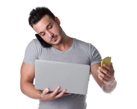 Overwhelmed by technology. young man with two cell phones and one laptop comp Stock Photos