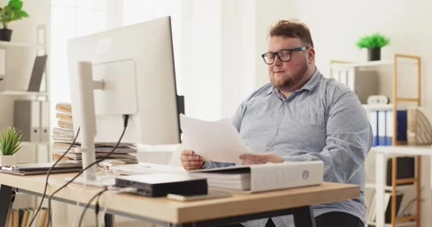 Overworked accountant at office computer with paperwork and budget analysis Stock Footage 337960392