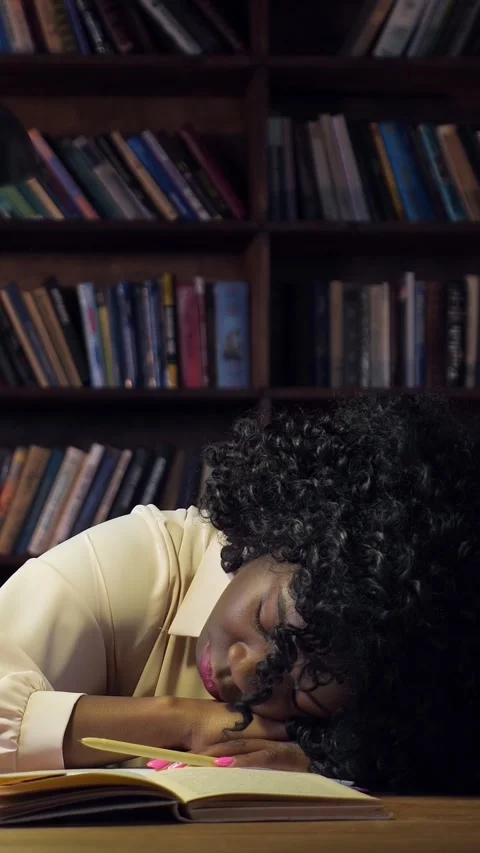 Overworked african american student falling asleep while studying in the library Video stock 341446983