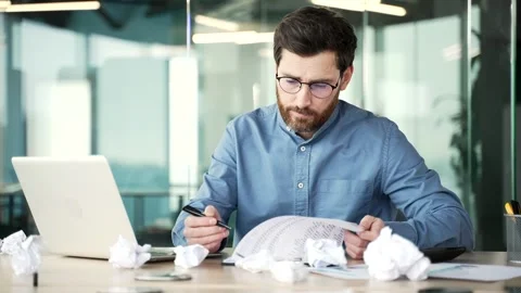 Overworked bearded financier in glasses is bored filling out documents sitting  Stock Footage 263984854