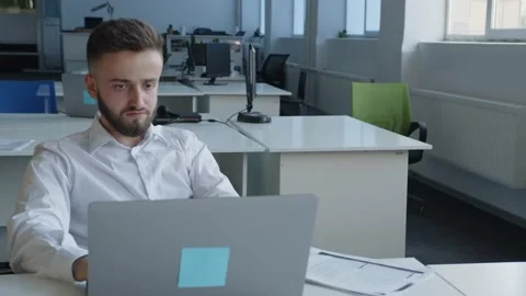 Overworked bearded man sits and looks on the computer Vídeo Stock 157672564