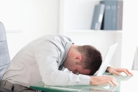 Overworked businessman taking a nap on his laptop Stock Photos