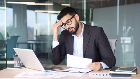 Overworked businessman is tired of doing paperwork and tasks on computer sitting Stock Footage 334861598