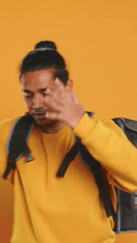 Overworked courier carrying huge stack of pizza boxes, studio background Video stock 274315638