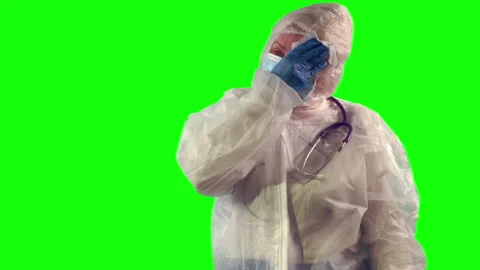 Overworked doctor is taking off a face shield and wipes sweat with a napkin Stock Footage 148292349