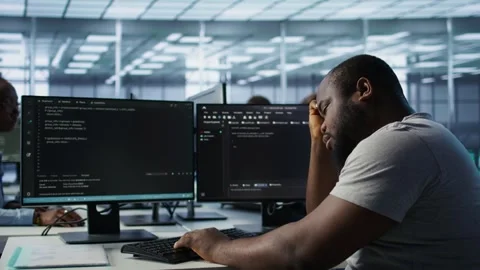 Overworked engineer falling asleep while typing on computer in server hub Stock Footage 319259509