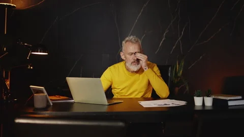 Overworked IT company boss taking off his glasses while working on a laptop Stock Footage 340902686