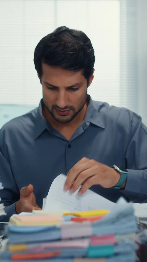 Overworked Latin businessman read document at office. 库存影片 344790558