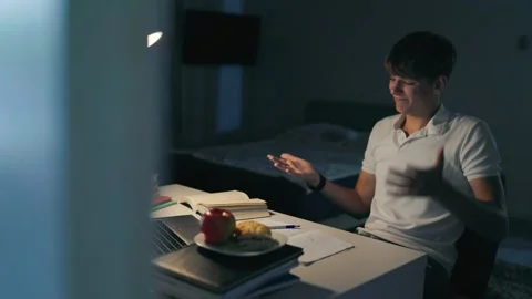 Overworked teenager crying at the dark study desk during a late learning session Stock Footage 345212140