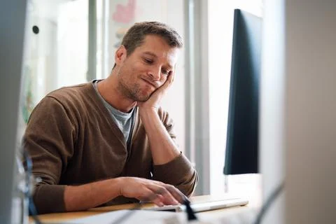 Overworked tired employee, programmer at workplace in office being unhappy Stock Photos