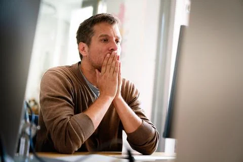 Overworked tired employee, programmer at workplace in office being unhappy Stock Photos