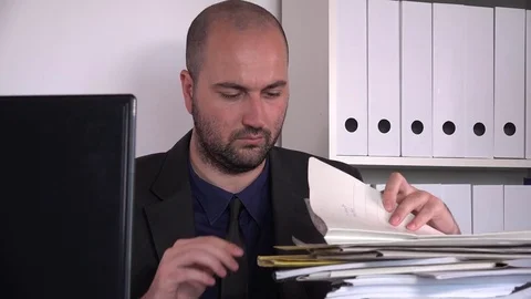 Overworked tired stressed business man indoors yawning tired at paperwork stack Stock Footage