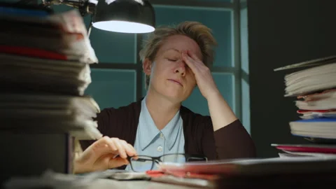 Overworked woman suffering from headache while working Stock Footage 295429616