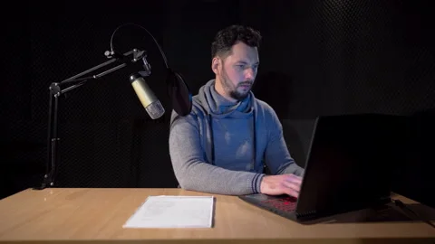 An overworked young handsome man working in front of a computer in studio Stock Footage 169250814