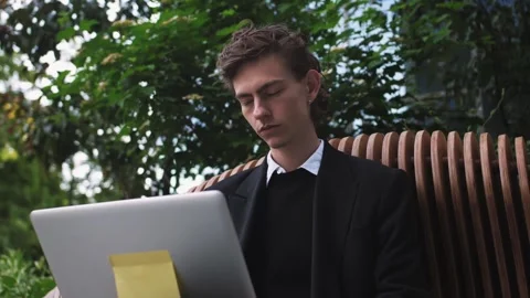 Overworked young worker feels tired and wants to sleep working on laptop while 스톡 동영상 243590816