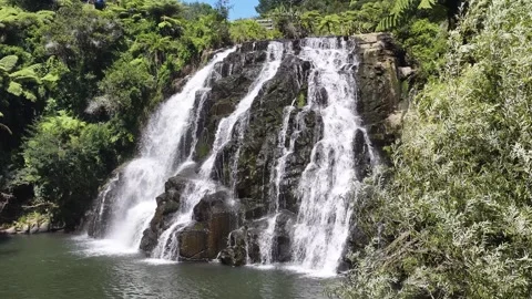 Owharoa Falls drops in multiple streams over a weathered rock ledge Stock Footage 341992397