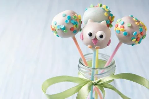 Owl cake pops with multi colored sprinkles in the bottle with blue smarties Stock Photos
