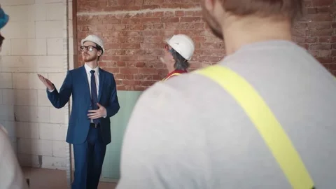 Owner and foreman shaking hands during meeting with crew Stock Footage 133636229