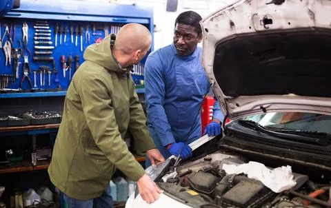 Owner of car explains the problem with car engine to mechanic of the car service 스톡 사진