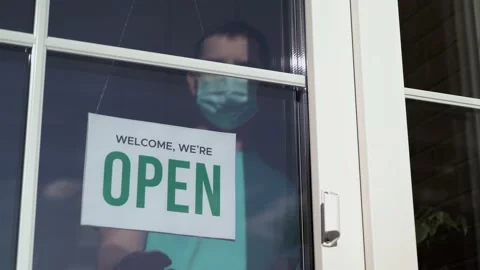 Owner changes sign from OPEN to TEMPORARILY CLOSED 库存影片 130564112